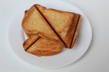 Beyaz tabakta, beyaz arka planda izole edilmiş tost ya da kızarmış ekmek.