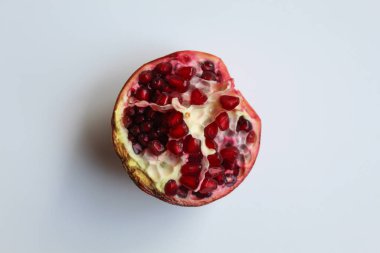 Nar meyvesinin içinde, beyaz arka planda izole edilmiş taze kırmızı tohumlar.