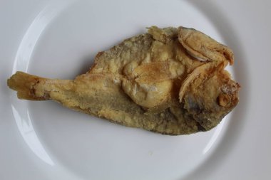 Bir parça kızarmış balık. Endonezya 'da Gereh veya Ikan Asin olarak adlandırılan tuzlama yöntemi, yarısı kesilmiş un kaplı balıkları korudu. Beyaz arkaplan, düz yatay veya üst görünümde izole edilmiş