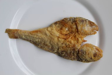 Bir parça kızarmış balık. Endonezya 'da Gereh veya Ikan Asin olarak adlandırılan tuzlama yöntemi, yarısı kesilmiş un kaplı balıkları korudu. Beyaz arkaplan, düz yatay veya üst görünümde izole edilmiş