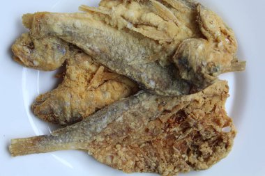 Kızarmış balık. Endonezya 'da Gereh veya Ikan Asin olarak adlandırılan tuzlama yöntemi, yarısı kesilmiş un kaplı balıkları korudu. Beyaz arkaplanda izole