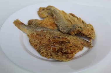 Kızarmış balık. Endonezya 'da Gereh veya Ikan Asin olarak adlandırılan tuzlama yöntemi, yarısı kesilmiş un kaplı balıkları korudu. Beyaz arkaplanda izole