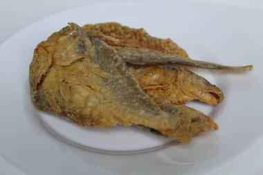 Kızarmış balık. Endonezya 'da Gereh veya Ikan Asin olarak adlandırılan tuzlama yöntemi, yarısı kesilmiş un kaplı balıkları korudu. Beyaz arkaplanda izole