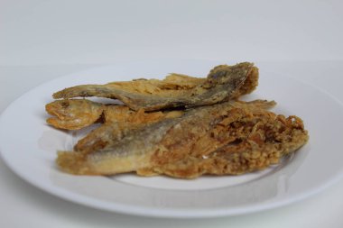 Kızarmış balık. Endonezya 'da Gereh veya Ikan Asin olarak adlandırılan tuzlama yöntemi, yarısı kesilmiş un kaplı balıkları korudu. Beyaz arkaplanda izole