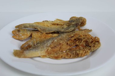 Kızarmış balık. Endonezya 'da Gereh veya Ikan Asin olarak adlandırılan tuzlama yöntemi, yarısı kesilmiş un kaplı balıkları korudu. Beyaz arkaplanda izole