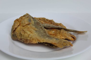 Kızarmış balık. Endonezya 'da Gereh veya Ikan Asin olarak adlandırılan tuzlama yöntemi, yarısı kesilmiş un kaplı balıkları korudu. Beyaz arkaplanda izole