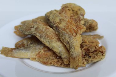 Kızarmış balık. Endonezya 'da Gereh veya Ikan Asin olarak adlandırılan tuzlama yöntemi, yarısı kesilmiş un kaplı balıkları korudu. Beyaz arkaplanda izole