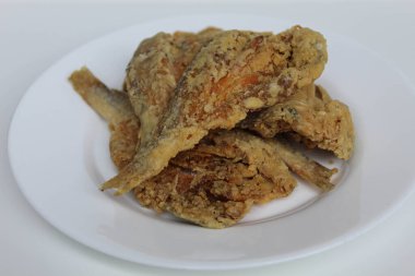 Kızarmış balık. Endonezya 'da Gereh veya Ikan Asin olarak adlandırılan tuzlama yöntemi, yarısı kesilmiş un kaplı balıkları korudu. Beyaz arkaplanda izole