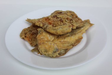 Kızarmış balık. Endonezya 'da Gereh veya Ikan Asin olarak adlandırılan tuzlama yöntemi, yarısı kesilmiş un kaplı balıkları korudu. Beyaz arkaplanda izole