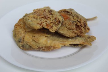 Kızarmış balık. Endonezya 'da Gereh veya Ikan Asin olarak adlandırılan tuzlama yöntemi, yarısı kesilmiş un kaplı balıkları korudu. Beyaz arkaplanda izole