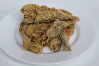 Kızarmış balık. Endonezya 'da Gereh veya Ikan Asin olarak adlandırılan tuzlama yöntemi, yarısı kesilmiş un kaplı balıkları korudu. Beyaz arkaplanda izole