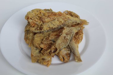 Kızarmış balık. Endonezya 'da Gereh veya Ikan Asin olarak adlandırılan tuzlama yöntemi, yarısı kesilmiş un kaplı balıkları korudu. Beyaz arkaplanda izole