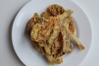 Kızarmış balık. Endonezya 'da Gereh veya Ikan Asin olarak adlandırılan tuzlama yöntemi, yarısı kesilmiş un kaplı balıkları korudu. Beyaz arkaplanda, beyaz plakada, düz yerde ya da üst görünümde izole edilmiş