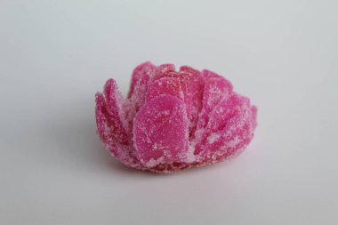 Manisan Pala, or candied nutmeg fruit, snack from Indonesia. In flower shaped, dried, covered by crystal sugar, isolated on white background clipart