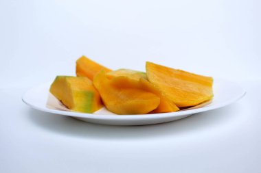 Taze sarı mango dilimleri, beyaz tabakta, beyaz arka planda izole.