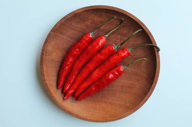 Biraz taze kırmızı biber, ahşap tabakta, beyaz arka planda izole, düz ya da üst manzara