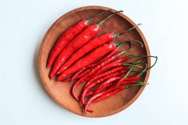 Biraz taze kırmızı biber, ahşap tabakta, beyaz arka planda izole, düz ya da üst manzara