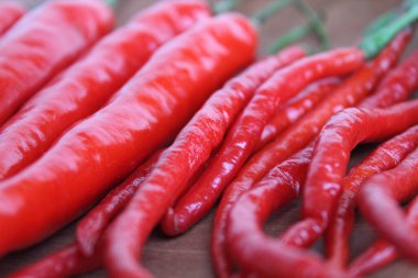 Close up view of some fresh big red chili, on wooden plate clipart