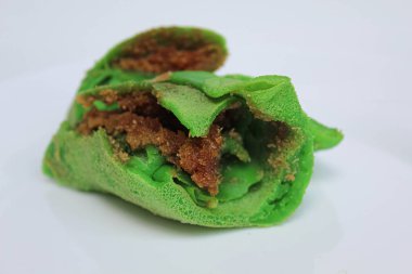 Dadar Gulung Isi Kelapa, Endonezya 'dan geleneksel tatlı. Yeşil renkli rulo krep, rendelenmiş hindistan cevizi ve kırmızı şeker. Beyaz arkaplanda izole