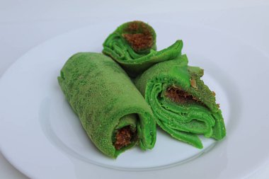 Dadar Gulung Isi Kelapa, Endonezya 'dan geleneksel tatlı. Dolgu olarak rendelenmiş hindistan cevizi ve palmiye şekerli yeşil krep. Beyaz arkaplanda izole