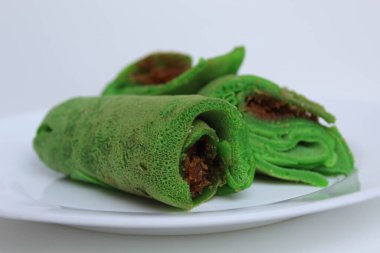 Dadar Gulung Isi Kelapa, Endonezya 'dan geleneksel tatlı. Dolgu olarak rendelenmiş hindistan cevizi ve palmiye şekerli yeşil krep. Beyaz arkaplanda izole