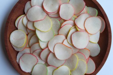 Kerupuk bawang pelangi ya da Endonezya 'dan gökkuşağı kenarlı sarımsaklı kraker. Pişmeden önce. Tahta tabakta, beyaz arkaplanda, düz yerde ya da üstte