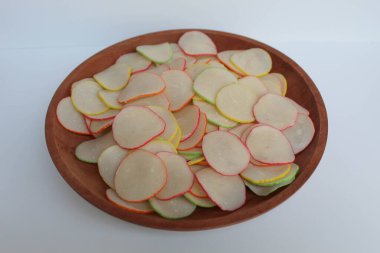 Kerupuk bawang pelangi ya da Endonezya 'dan gökkuşağı kenarlı sarımsaklı kraker. Pişmeden önce. Tahta tabakta, beyaz arka planda izole.