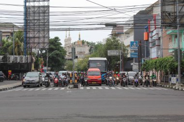 Araç ve insanlar kırmızı ışıkta durdu, sıraya girdiler, ön manzara. Semarang, Endonezya, 25 Aralık 2022