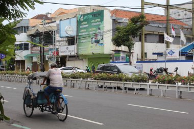 Sokakta araba kullanan bir taksi şoförü, arka manzara. Semarang, Endonezya, 25 Aralık 2022