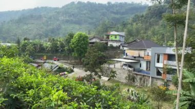 Karanganyar, Endonezya - 22 Eylül 2024: Kemuning turistik merkezi, yürüyen ve binen insanlar, ağaçlı yeşil tepe, konut alanı