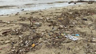 Jepara, Endonezya - 3 Şubat 2024: Atık ve çamurlu deniz suyuyla kirli plaj