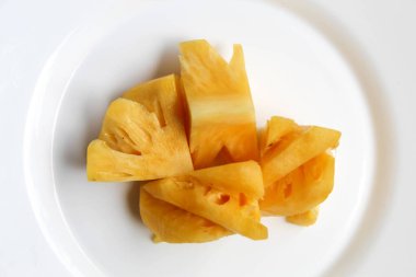 Beyaz tabakta ananas etini kes, beyaz arkaplanda izole edilmiş, düz ya da üst görünümde
