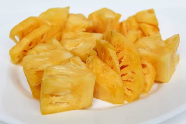 Ananas etini beyaz tabakta kes, beyaz arka planda izole et.