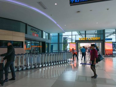 Tangerang, Endonezya - 1 Şubat 2025: Subay Soekarno Hatta Uluslararası Havalimanı Doğu Lobisi 'nde bir sıra vagon veya yük arabası itiyor