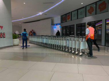 Tangerang, Endonezya - 1 Şubat 2025: Subay Soekarno Hatta Uluslararası Havaalanı 'nda bir sıra yük arabası veya yük arabası sürüyor