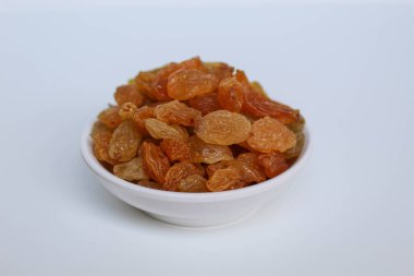 Beyaz arka planda izole edilmiş küçük beyaz bir kasede kuru üzümler.