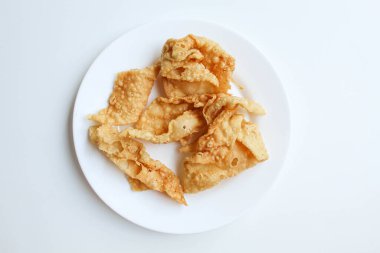 Kerupuk pangsit, ya da beyaz tabakta kızarmış cilt hamur, beyaz arka planda izole, düz ya da üst görünüm