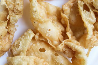 Kerupuk pangsit ya da beyaz arka planda izole edilmiş kızarmış deri hamur tatlısı.