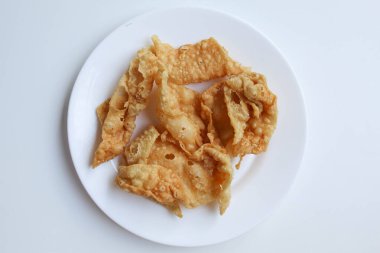 Kerupuk pangsit, ya da beyaz tabakta kızarmış cilt hamur, beyaz arka planda izole, düz ya da üst görünüm