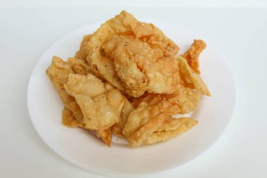 Kerupuk pangsit, ya da beyaz arka planda izole edilmiş beyaz bir tabakta kızarmış deri hamur köftesi.