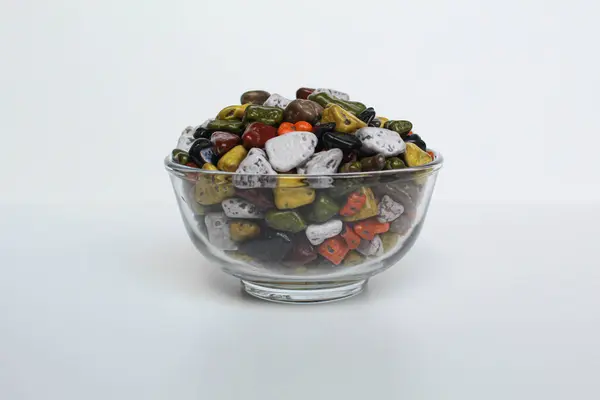 Türk, beyaz arka planda izole edilmiş şeffaf bir kasede çikolatayı sallıyor