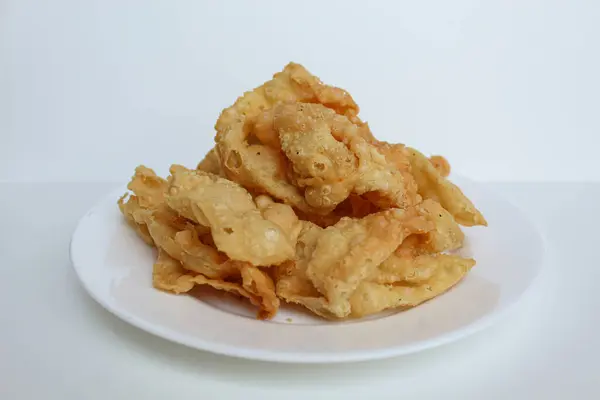 Kerupuk pangsit, ya da beyaz arka planda izole edilmiş beyaz bir tabakta kızarmış deri hamur köftesi.