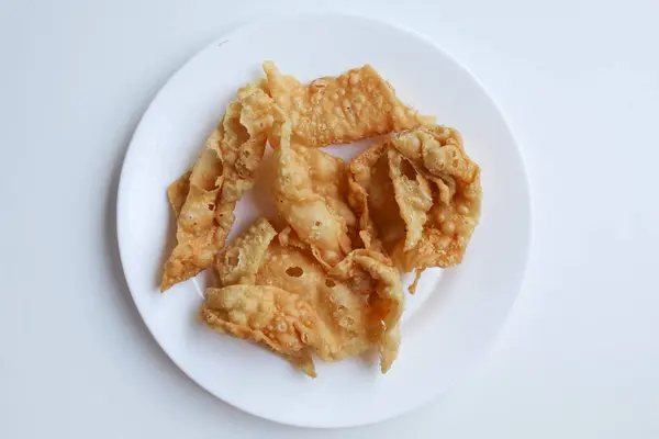 Kerupuk pangsit, ya da beyaz tabakta kızarmış cilt hamur, beyaz arka planda izole, düz ya da üst görünüm