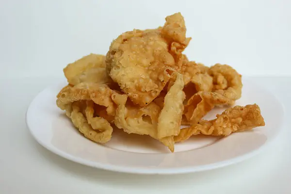 Kerupuk pangsit, ya da beyaz arka planda izole edilmiş beyaz bir tabakta kızarmış deri hamur köftesi.