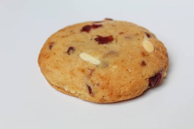 Beyaz arka planda izole edilmiş badem ve böğürtlen kesimli beyaz çikolatalı kurabiye.