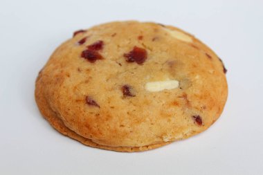 Beyaz arka planda izole edilmiş badem ve böğürtlen kesimli beyaz çikolatalı kurabiye.