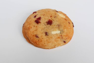 Beyaz arka planda izole edilmiş badem ve böğürtlen kesimli beyaz çikolatalı kurabiye.