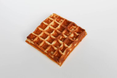 Bir sade kare waffle keki, yanmış, beyaz arka planda izole edilmiş.