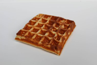 Bir sade kare waffle keki, yanmış, beyaz arka planda izole edilmiş.
