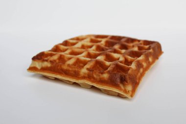 Bir sade kare waffle keki, yanmış, beyaz arka planda izole edilmiş.